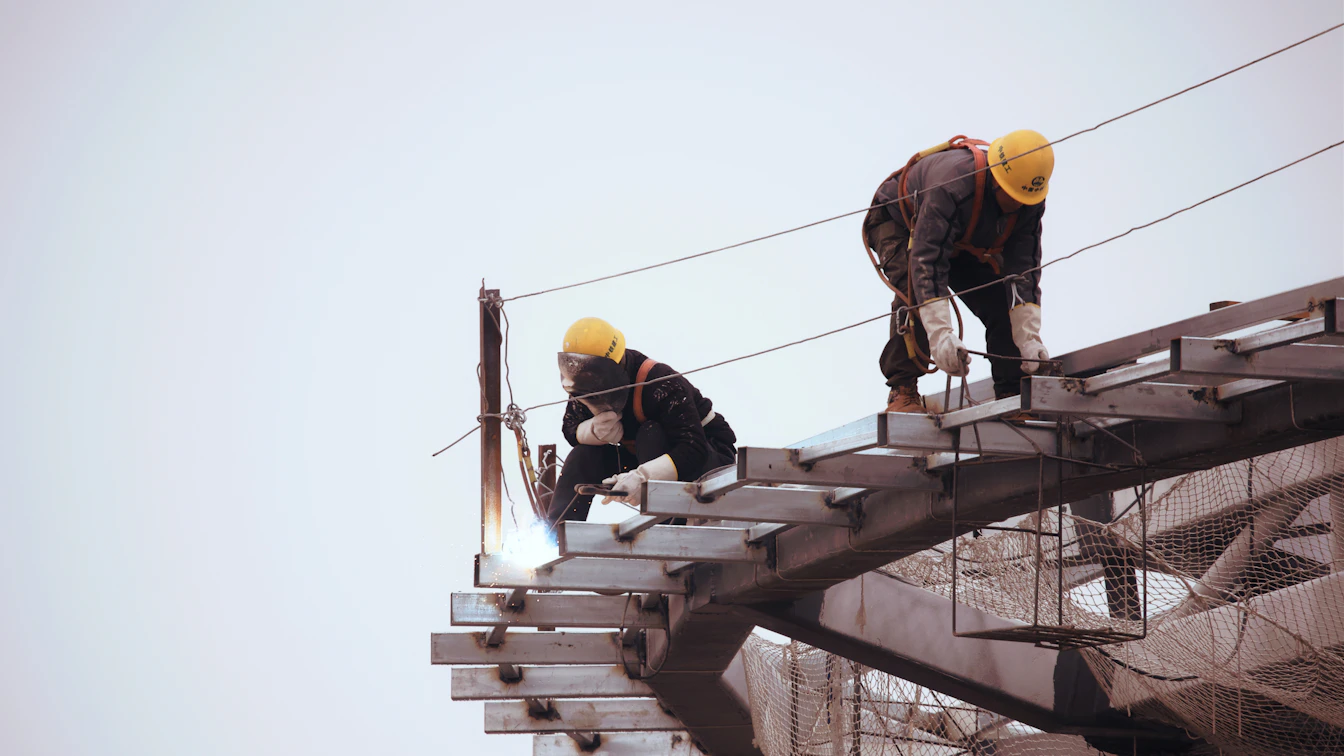 Un ouvrier roumain qualifié souriant, portant un casque de sécurité sur un chantier.